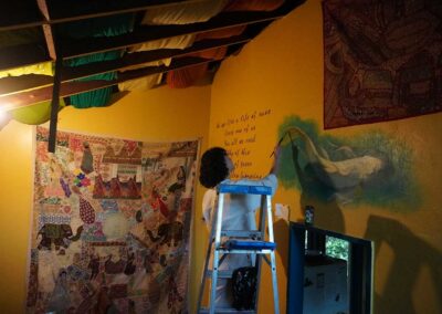 Artist Victoria from Washington painting a mural in the Yellow Submarine Kitchen Temple.