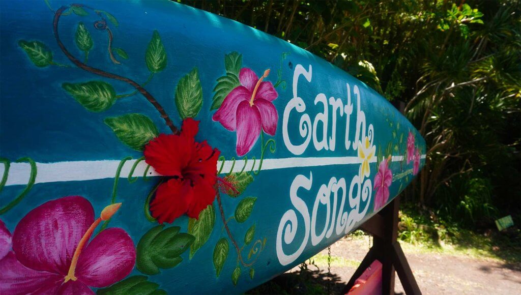 a blue surfboard with flowers painted on it. Earthsong Foundation Hawaii's Summer Camp 2025.